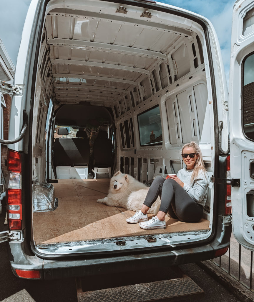 Jane sitting with Luka in our empty campervan