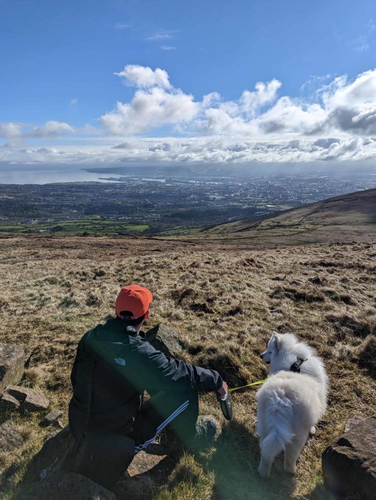 Andrew & Luka (our white fluffy Samoyed dog) checking our the views over the city of Belfast from the top of the Summit Trail Divis Mountain.