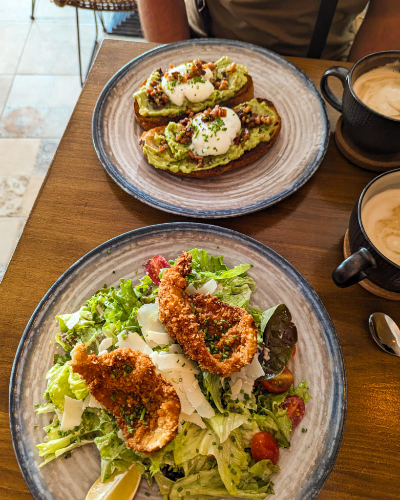 this photo shows our lunch we had at Almirante Brunch. Avocado with poached eggs on sourdough bread, and crispy chicken on bed of caesar salad.