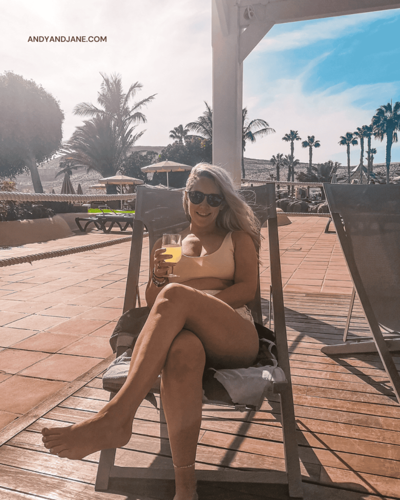 Jane sitting on a deckchair holding a drink in the Privilege Terrace