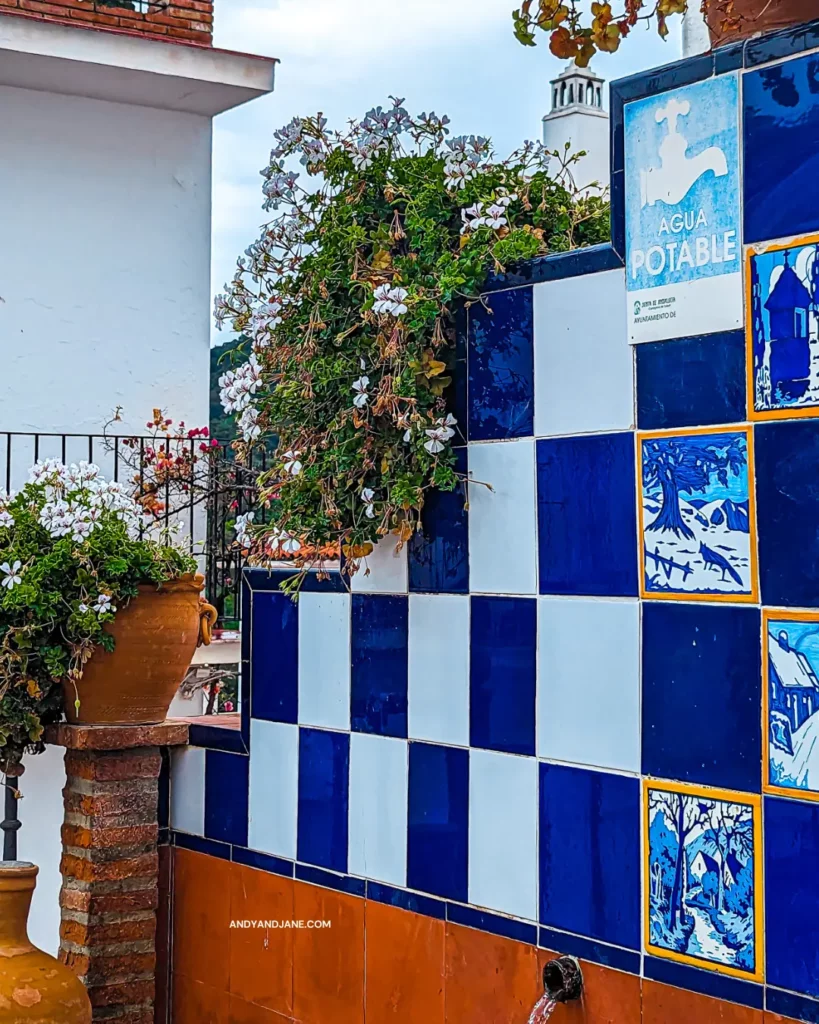 The blue and white tiles of El Churro Fountain with a sign saying 'Agua Potable'