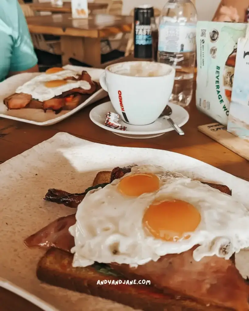 Two poached eggs on top of toasted bread and a coffee sitting on the table.