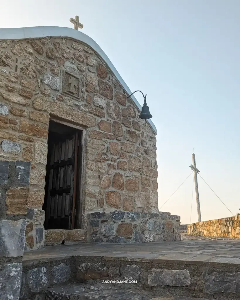 A small stone chapel with a bell & a cross engraved above the door.