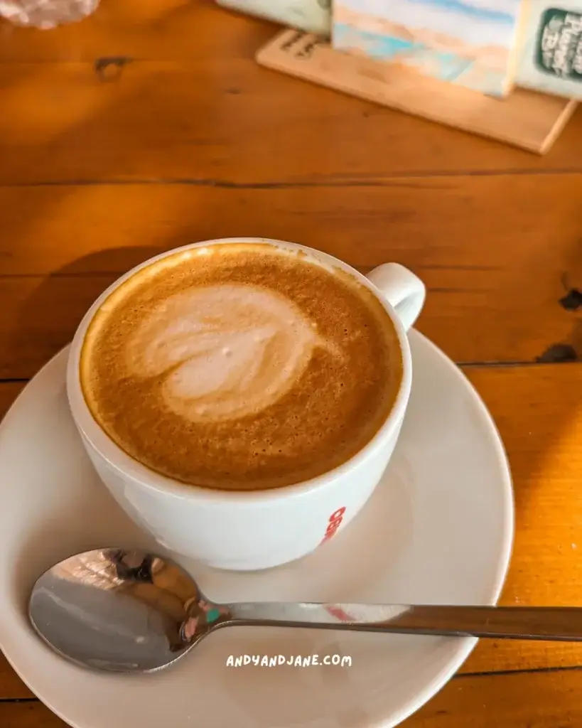 A cappucino in a white cup sitting on a table.