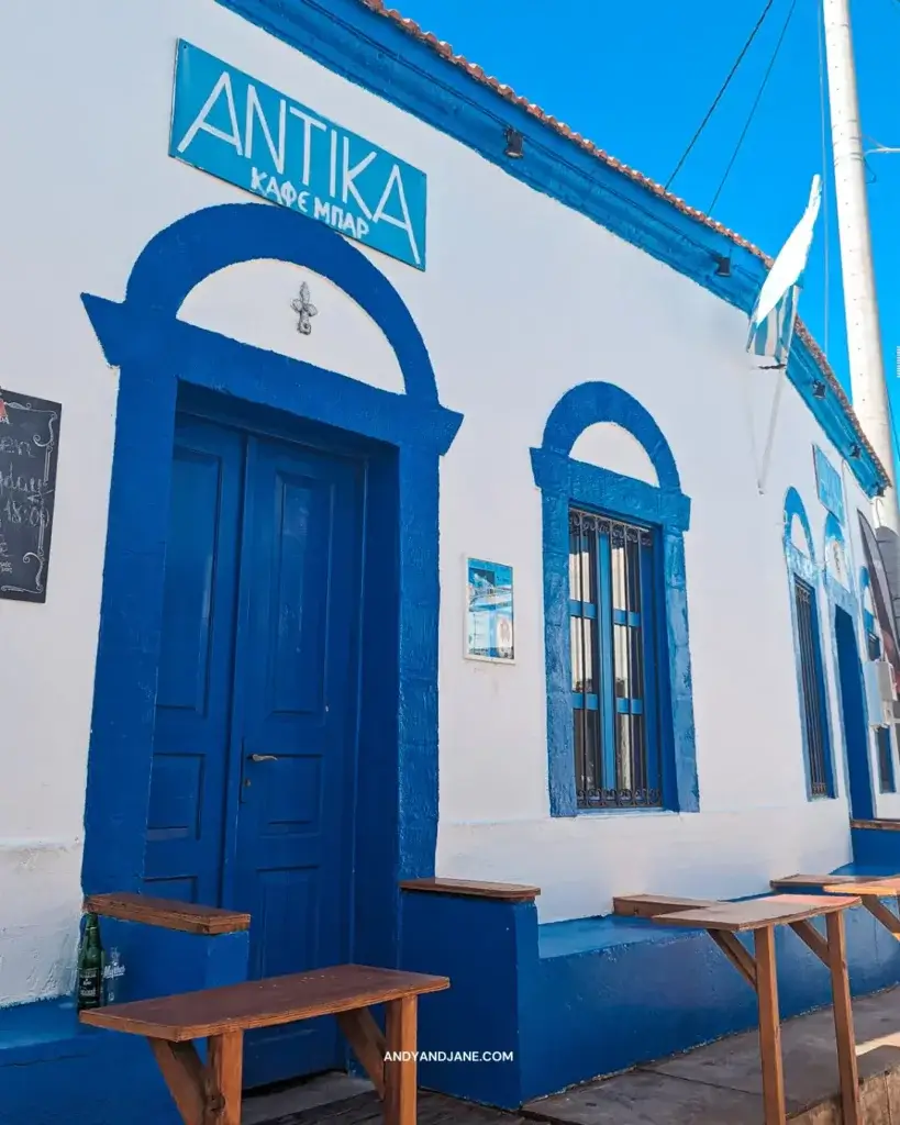 A small bar in Gennadi called Antika, with a blue door, windows & seats outside.