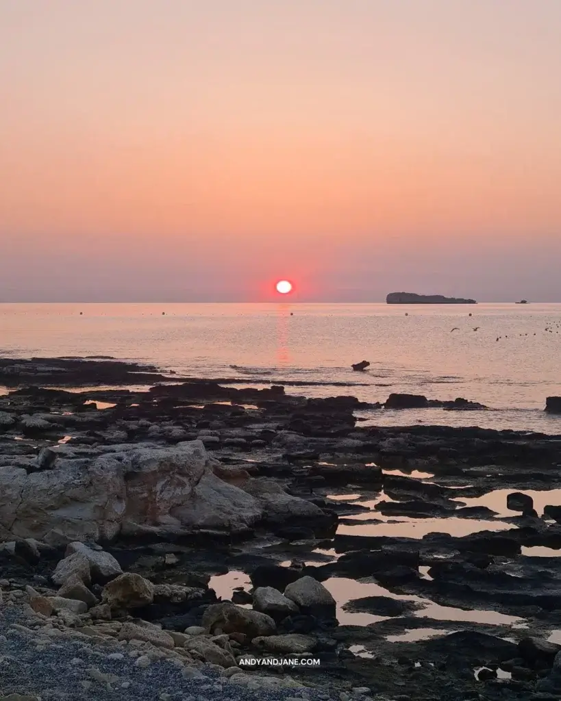 The sunrise coming up on the horizon in the sea.