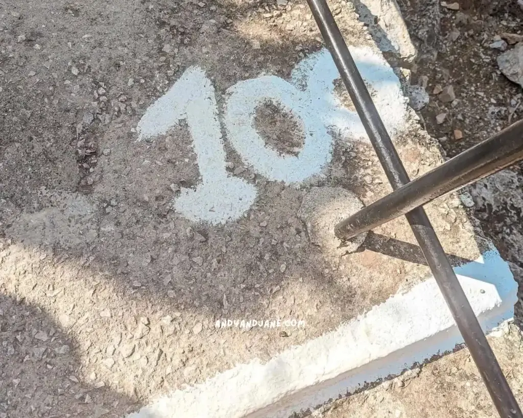 Steps leading to Tsambika Monastery with the number 100 painted in white on the ground.