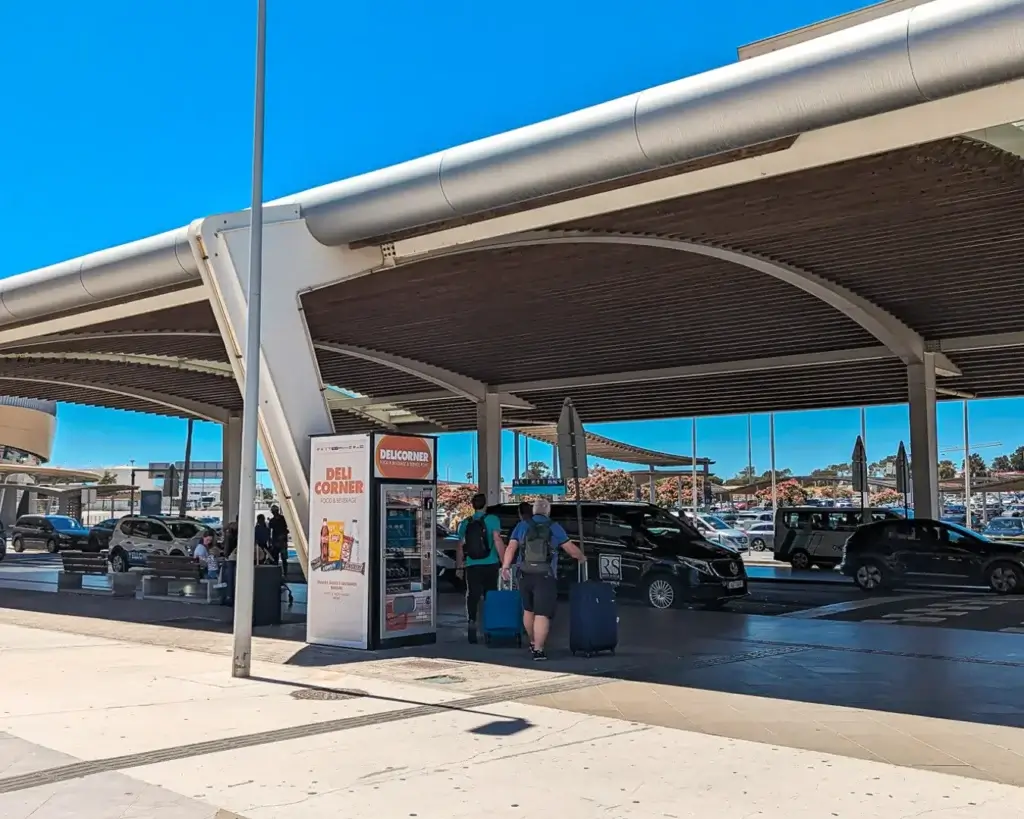 The taxi and pick-up area at Faro Airport with a large roof above it.