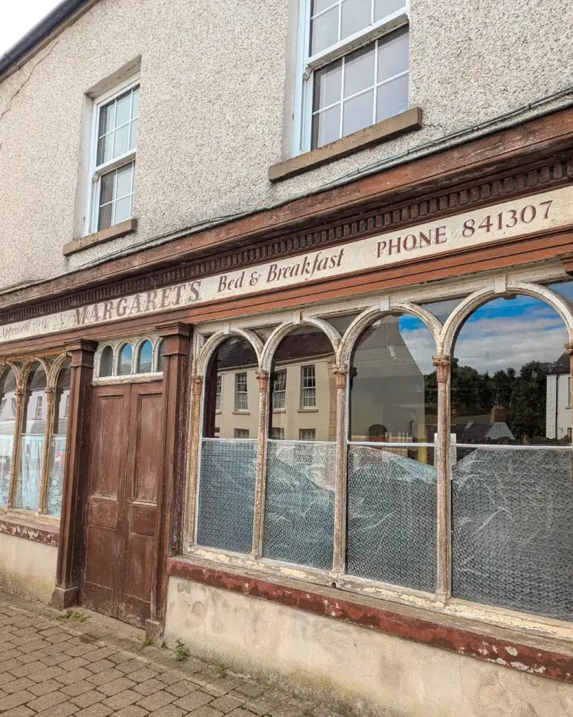 Vintage facade of "Margaret's Bed & Breakfast" with arched windows and a phone number.