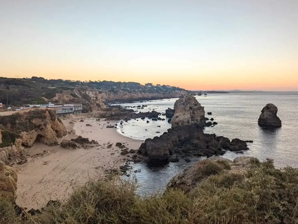 a view of a beach with rocks and water