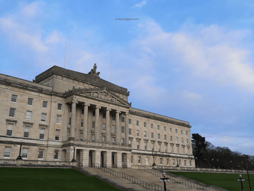 The imposing Stormont Parliament Buildings in Belfast, showcasing classical architecture against a blue sky backdrop.